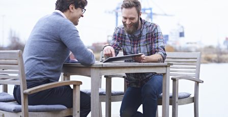 Two male designers having meeting on waterfront outside design studio