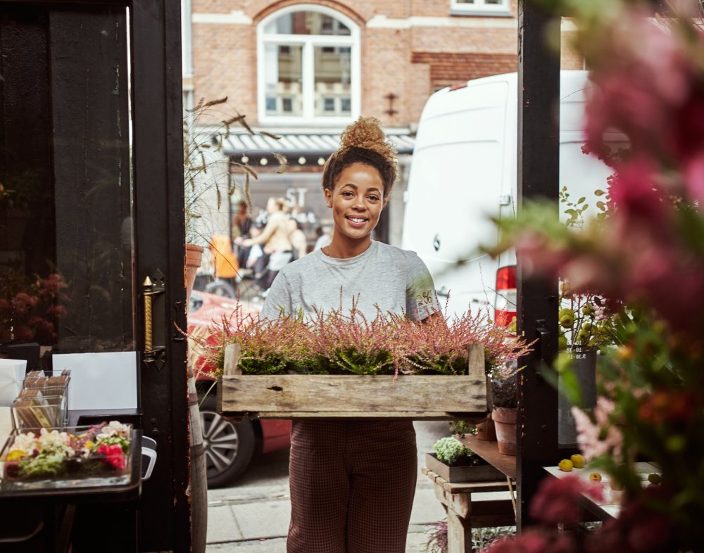 Florist standing holding a crate of flowers