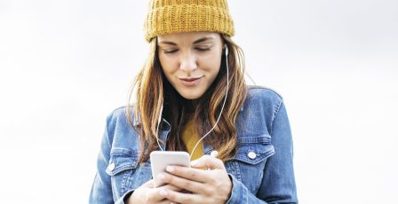 Woman wearing headphones looking at her mobile phone