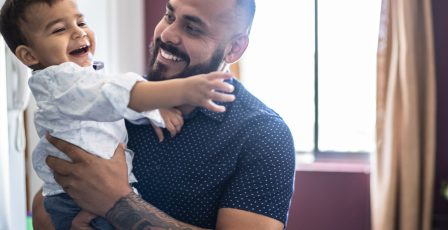 Father and son smiling at home