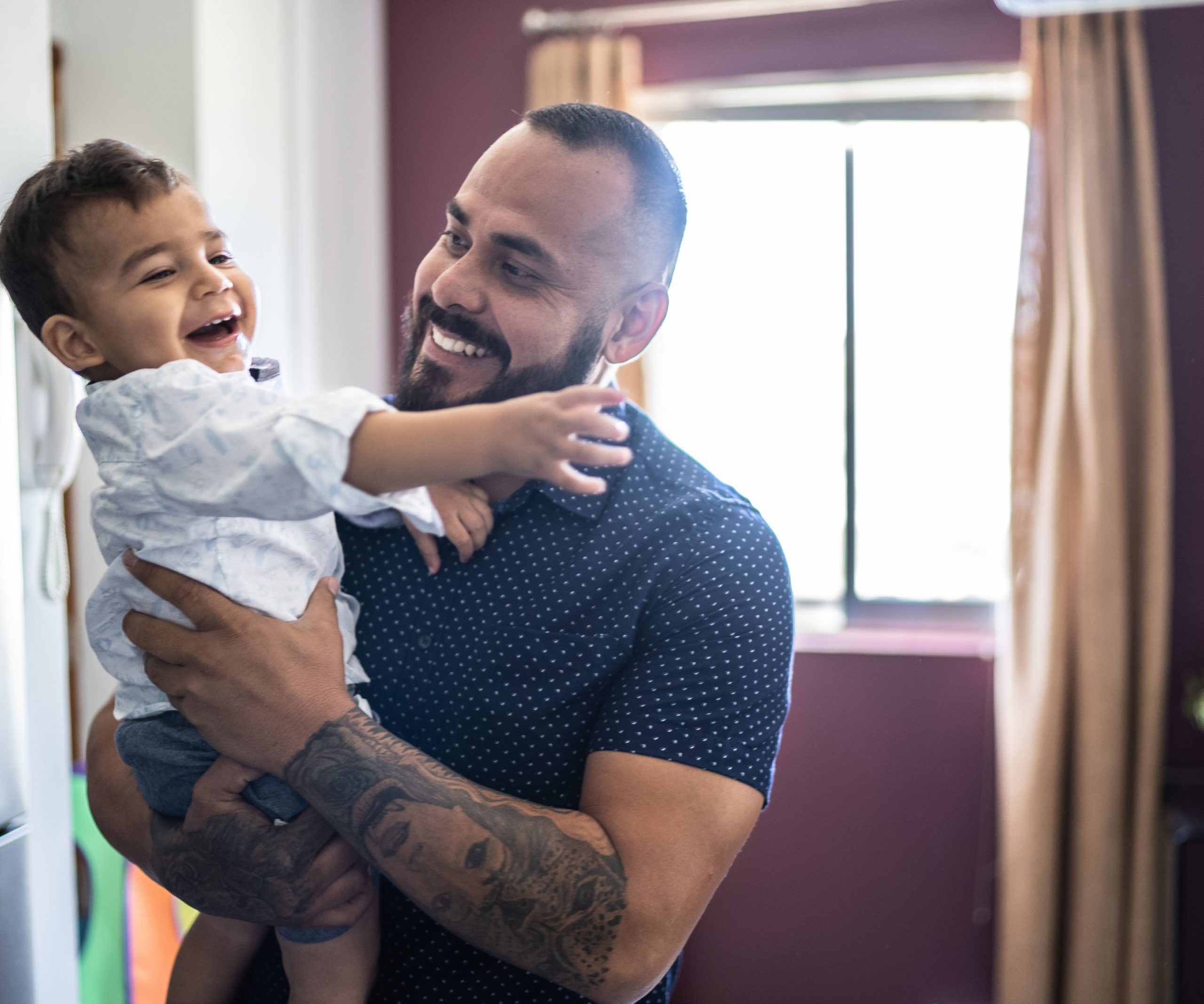 Father and son smiling at home