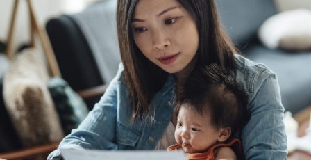 Woman working from home with her child on her lap
