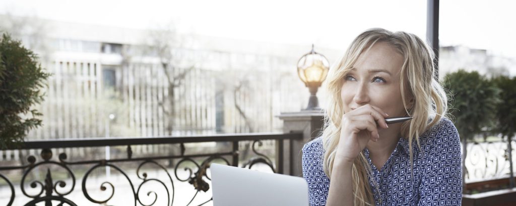 Female blogger working in coffee shop, using laptop