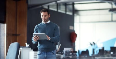 A businessperson working on their tablet in the office