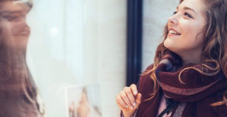 Shoppers looking at clothes in a shop window