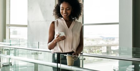 Woman in an office block using her mobile phone to verify her identity