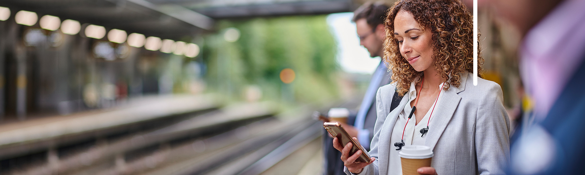 Woman looking at her mobile phone on a train platform