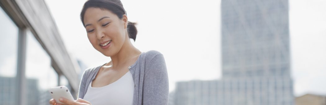 Young woman using her mobile phone to shop online