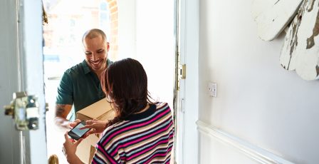 Delivery driver asking a resident to sign for a parcel