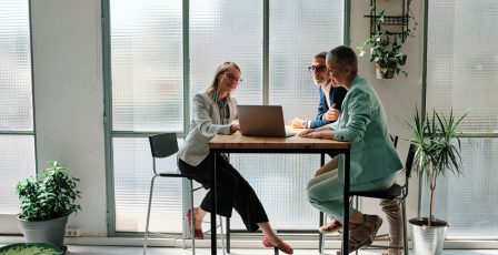 Colleagues gathered round a computer while brainstorming