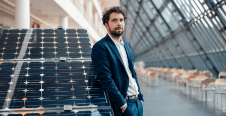 Man stood by solar panels.