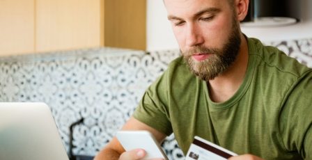 Young man depositing money into his online gaming account