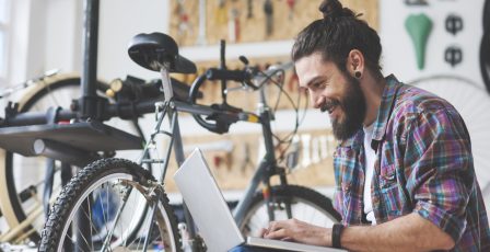 Man working at his bike service using laptop