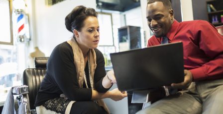 Small business owners looking at accounts on a laptop