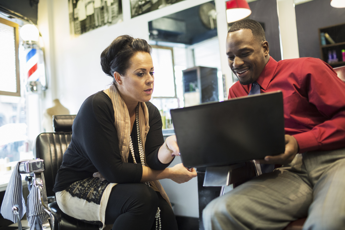 Small business owners looking at accounts on a laptop