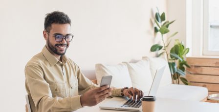 Young man conducting online checks using his mobile phone