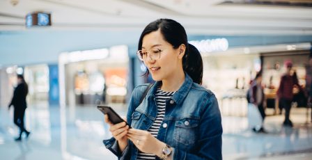 Woman in a shopping centre using her mobile phone