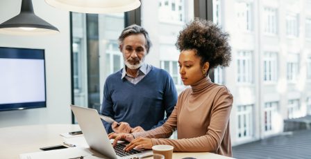 Colleagues looking at fraud data on a laptop