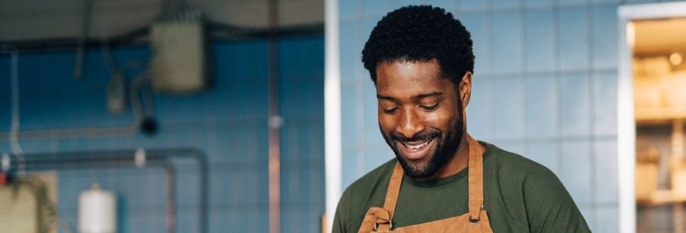 Man smiling in the kitchen of his small business