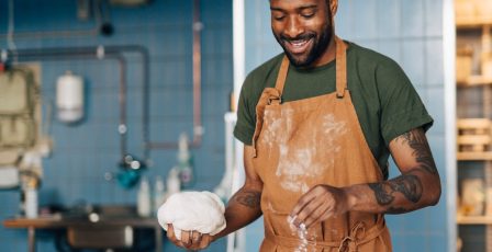 Man smiling in the kitchen of his small business