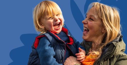 A woman holding her child, laughing together