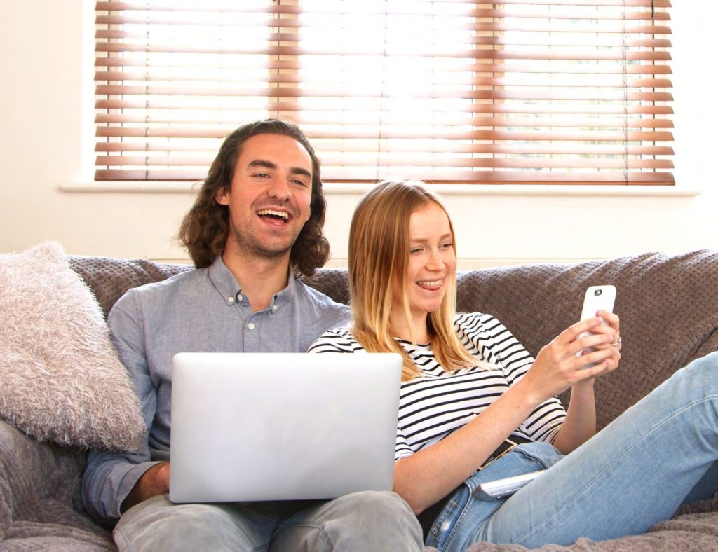 Image showing a couple on the sofa using different devices