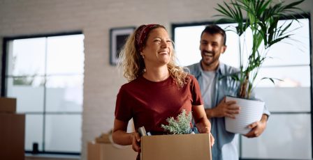 A happy couple holding items, ready to move house