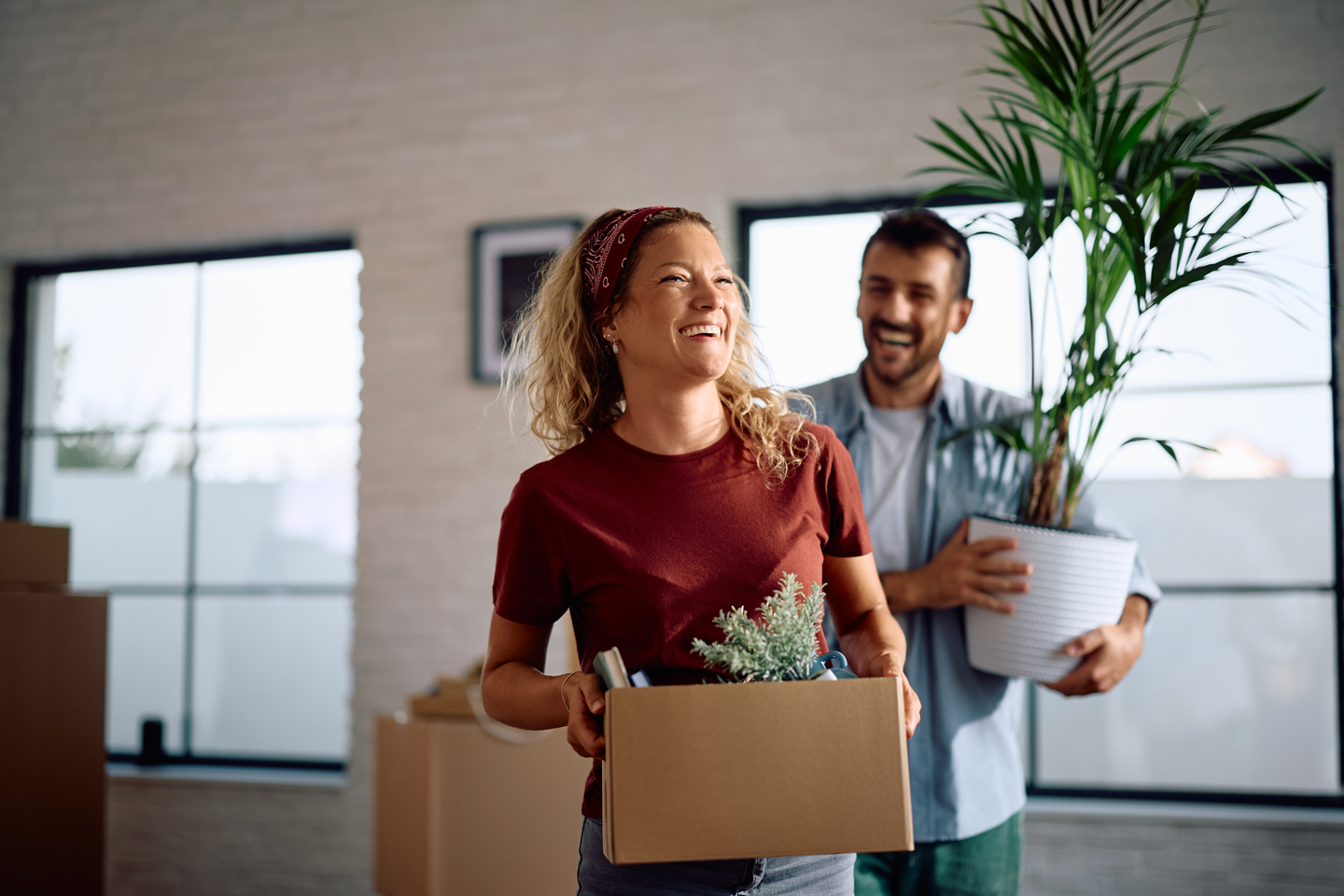 A happy couple holding items, ready to move house