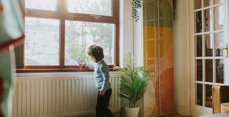 Young boy stood alongside a heater