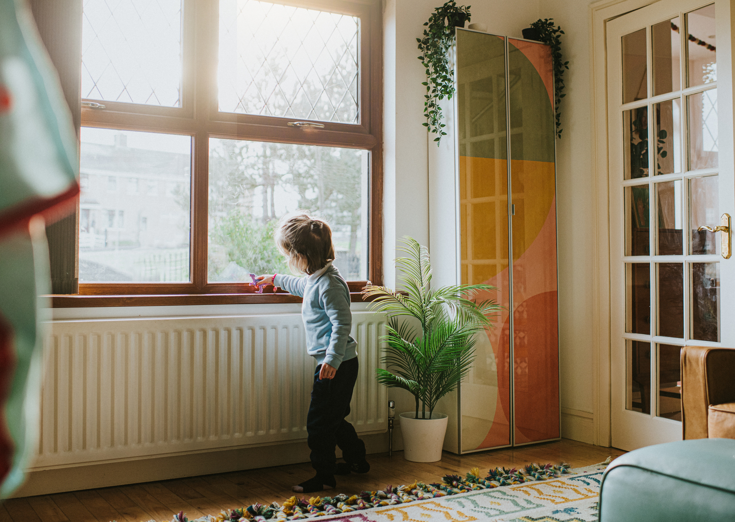 Young boy stood alongside a heater
