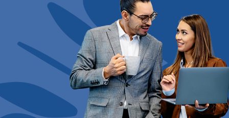 Couple wearing suits and looking over a laptop