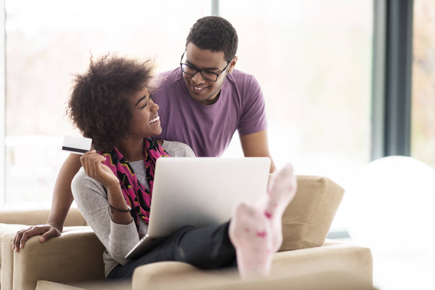 A couple smiling while purchasing an item online