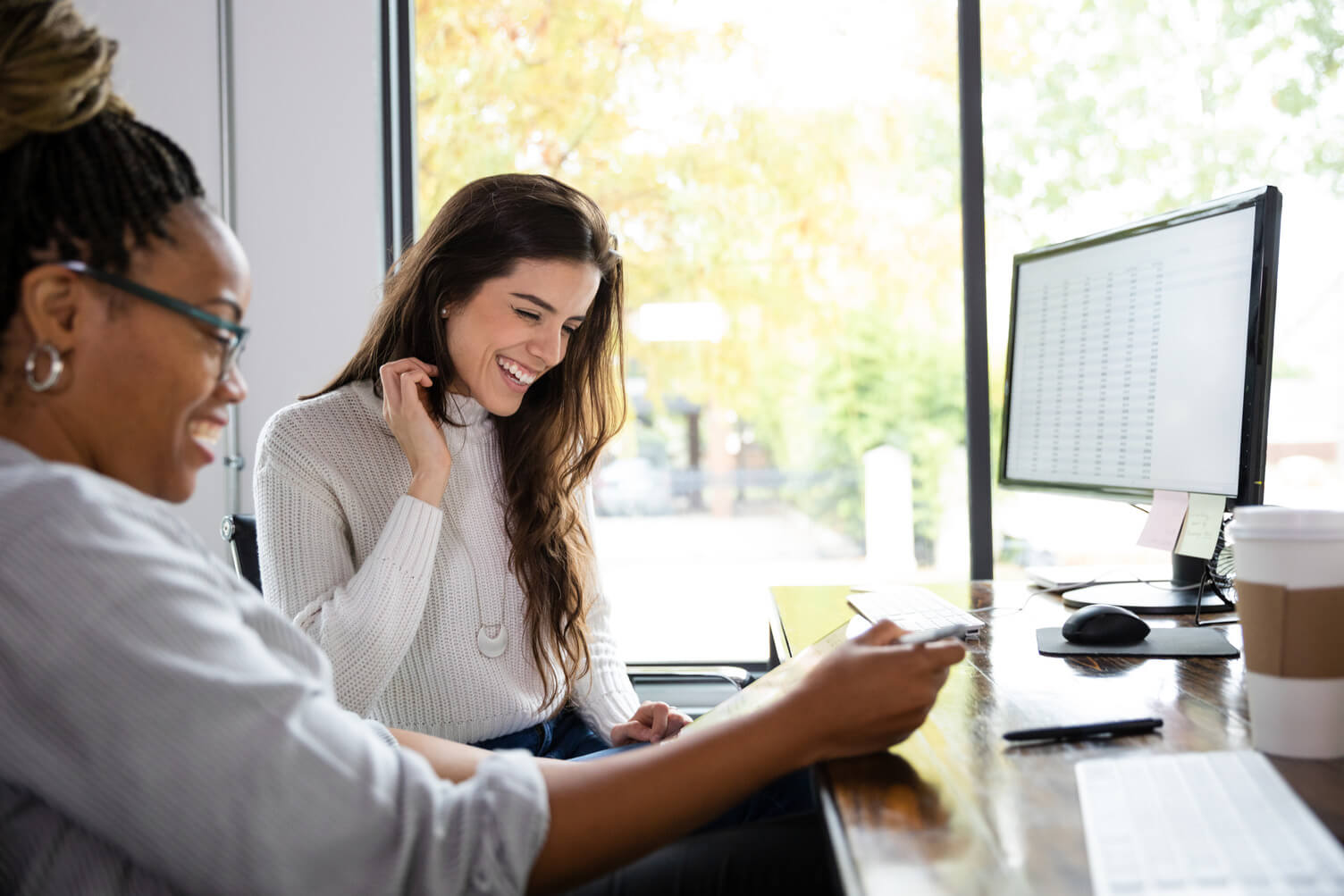 Two employees looking at data on a computer