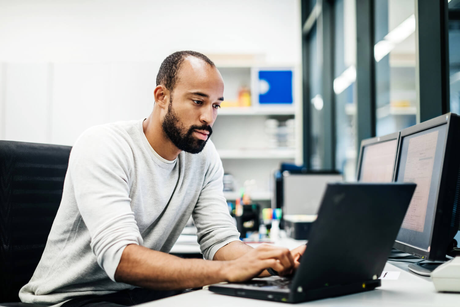 Man typing on a laptop in an office