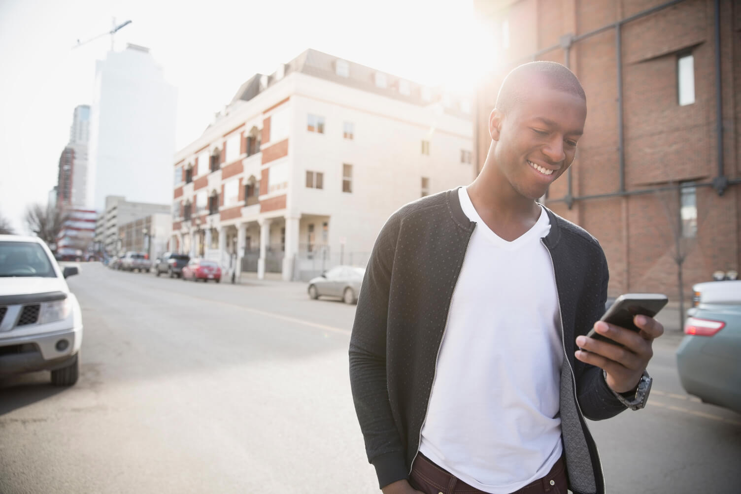 A man smiling at his phone