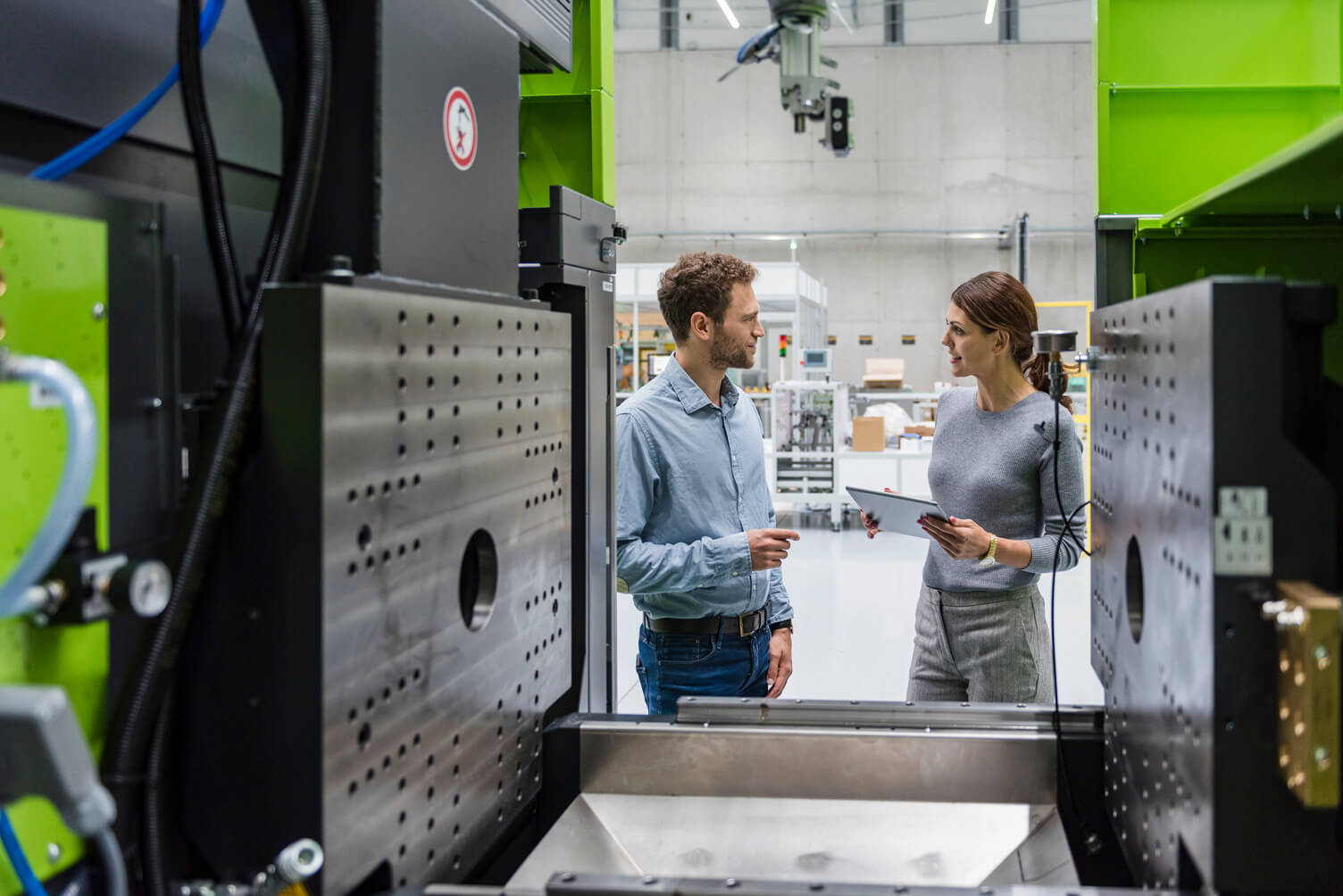 Two colleagues in front of machinery