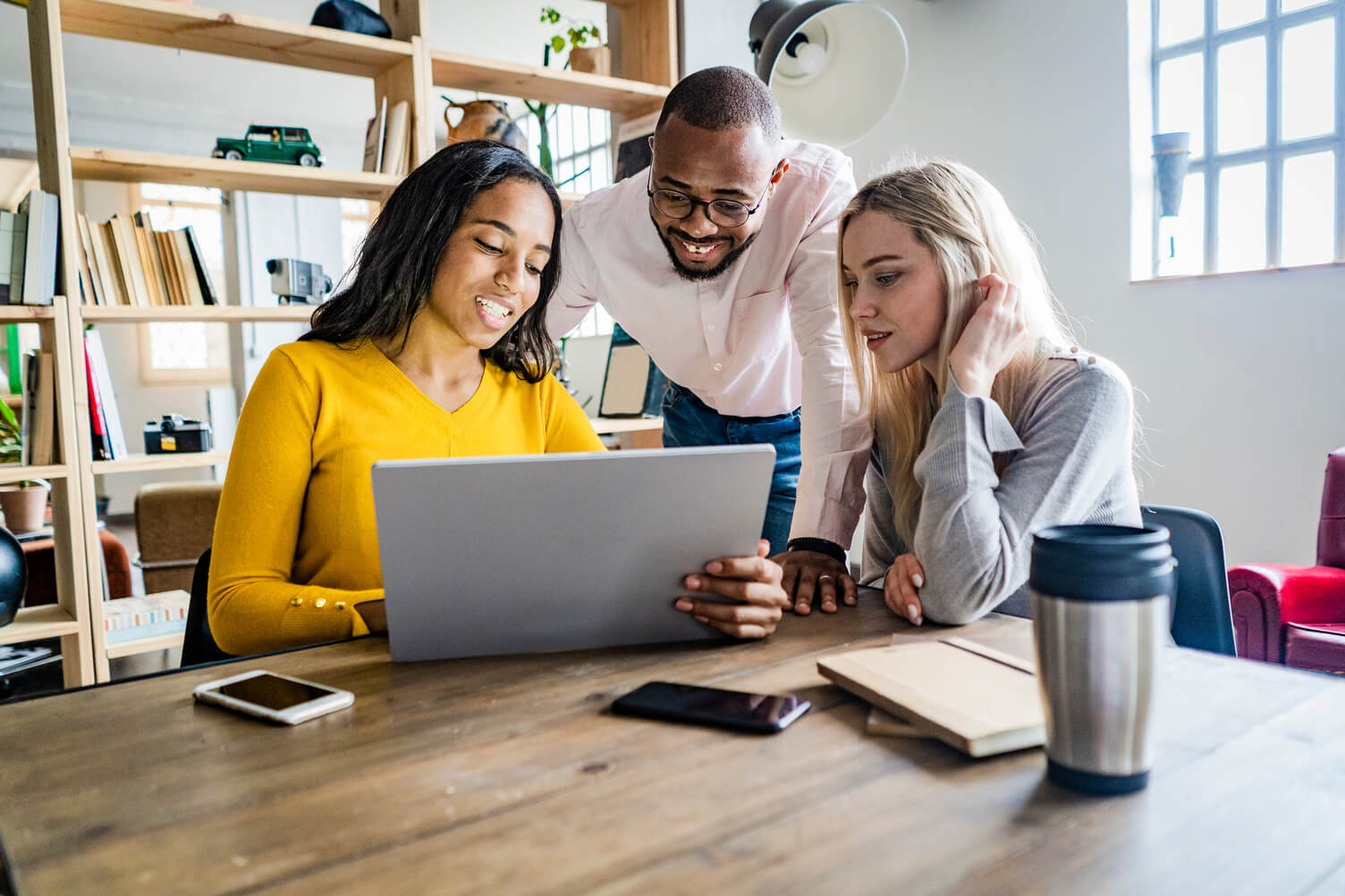 three people looking at laptop