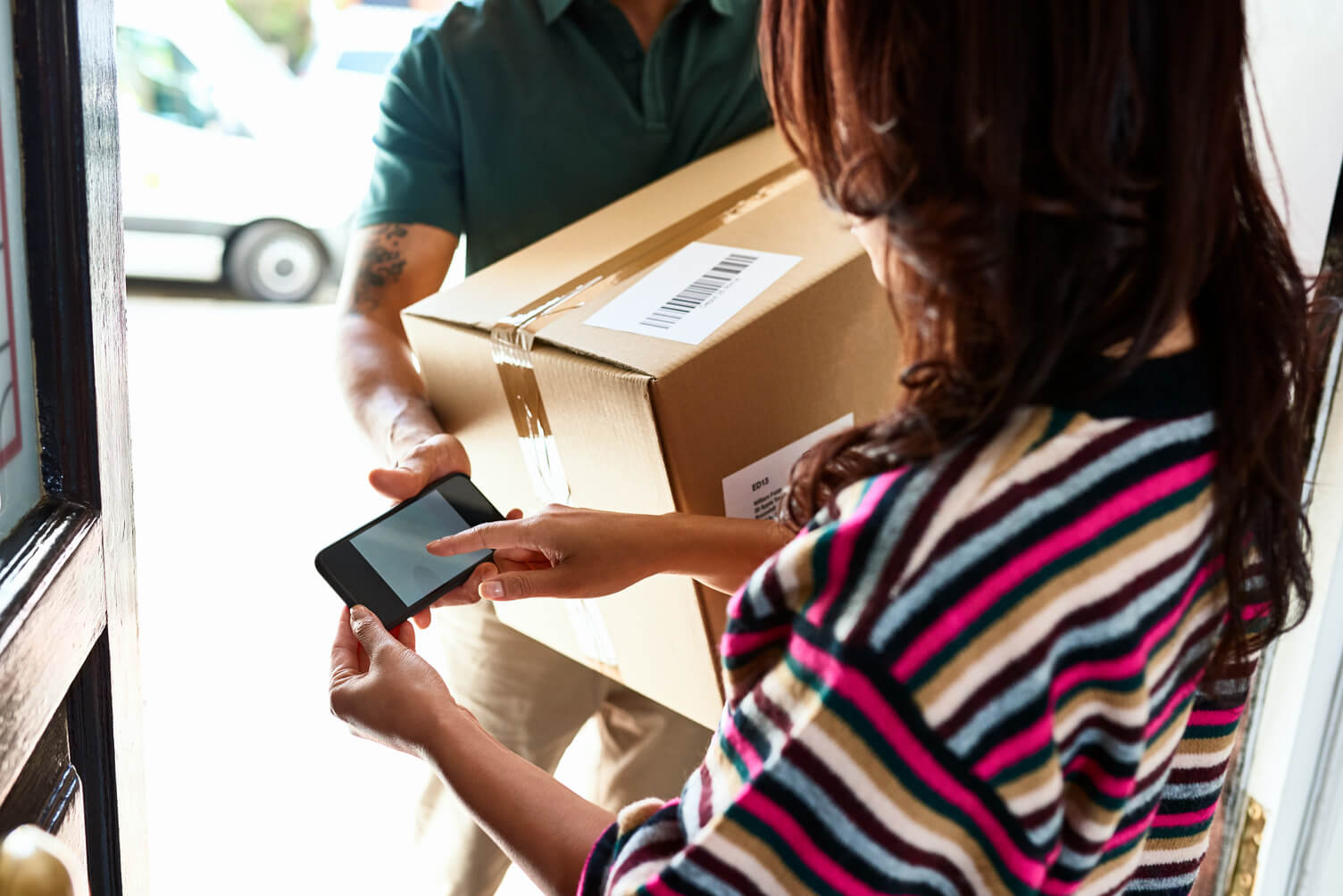 Woman receiving a parcel at home