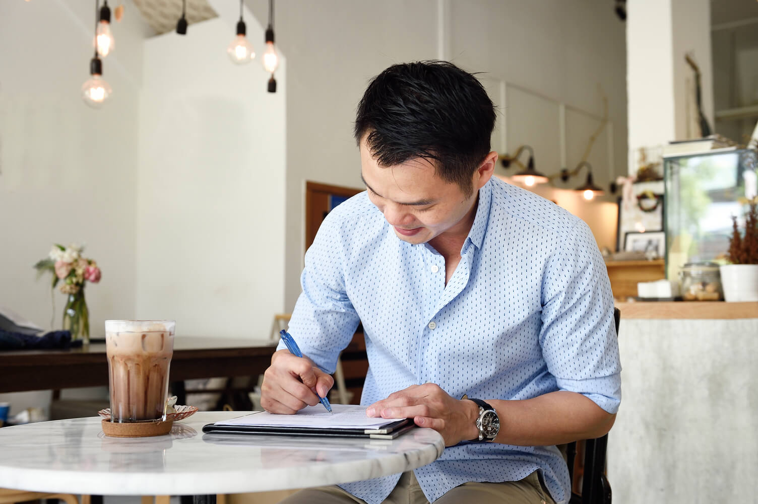 Man making notes in a coffee shop