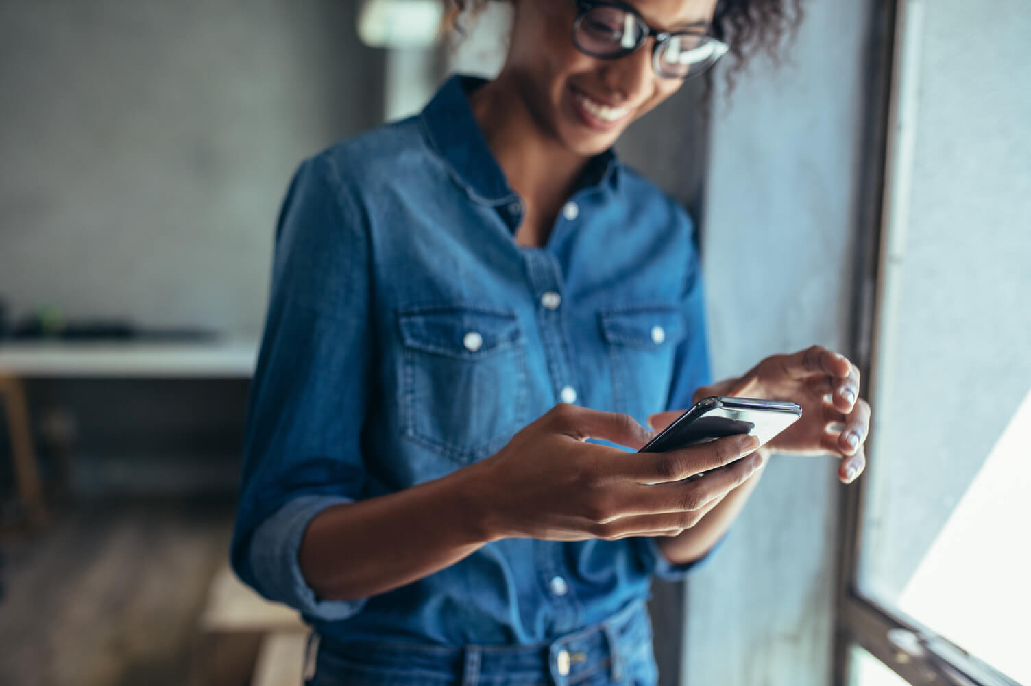 Woman smiling while using her mobile phone