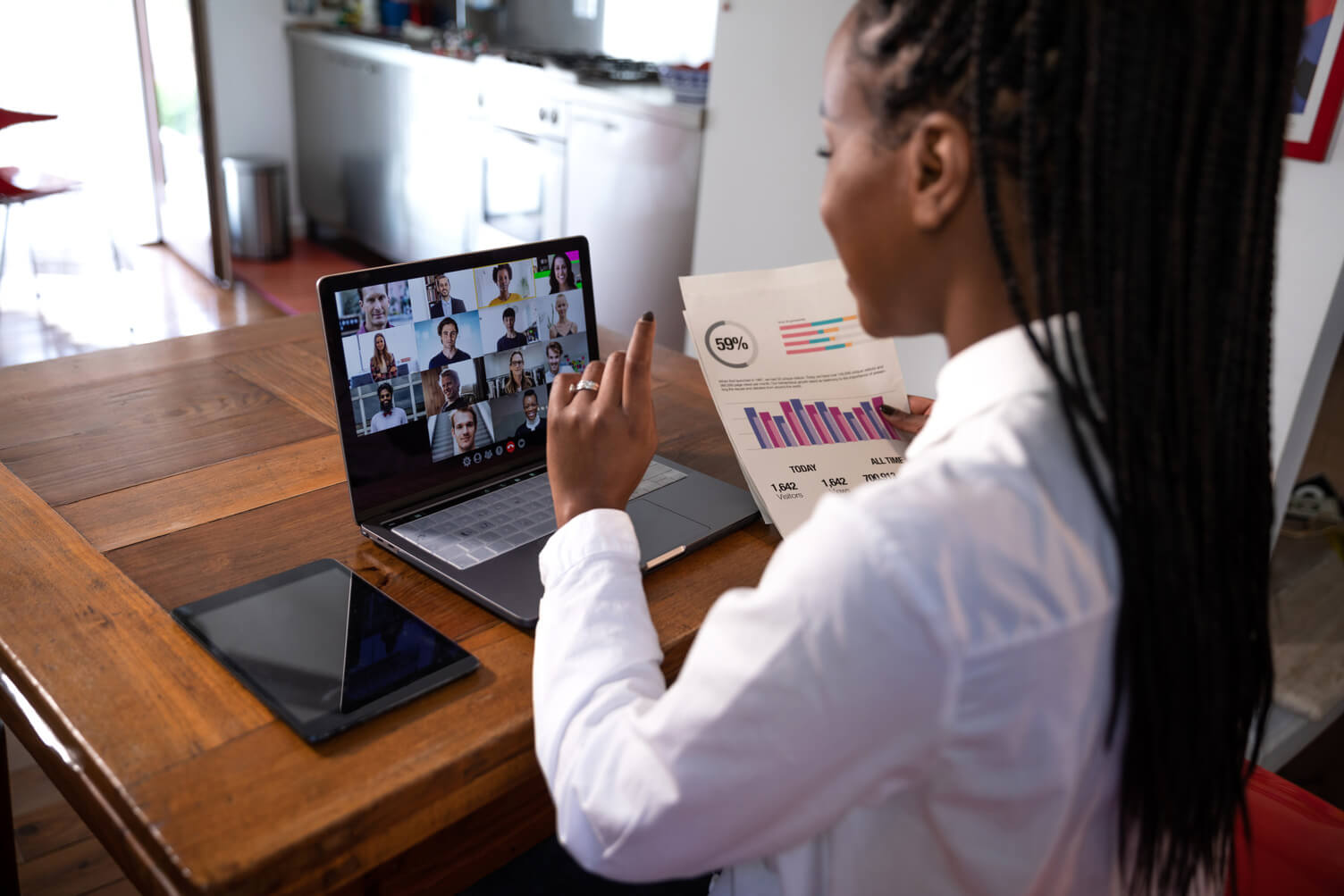 Woman taking through data on a video call with colleagues