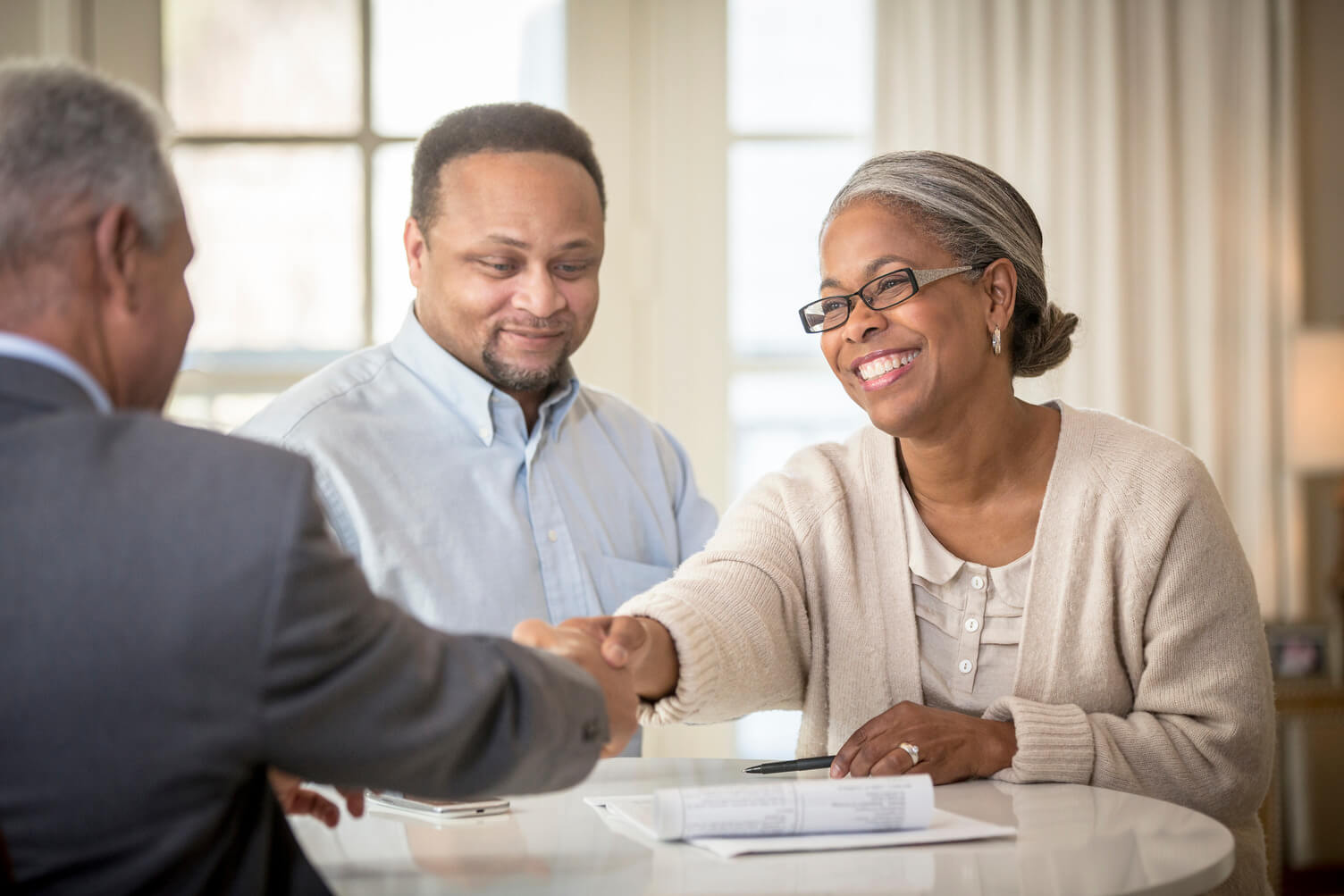 Lady shaking hands with man at desk