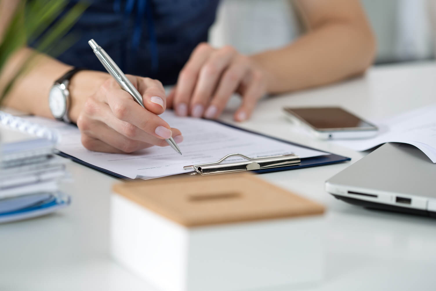 Person writing on a clipboard