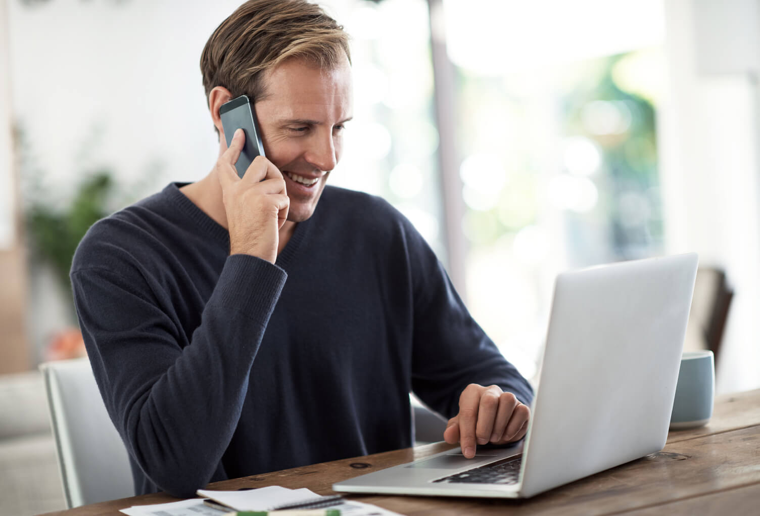 Man talking on phone with laptop