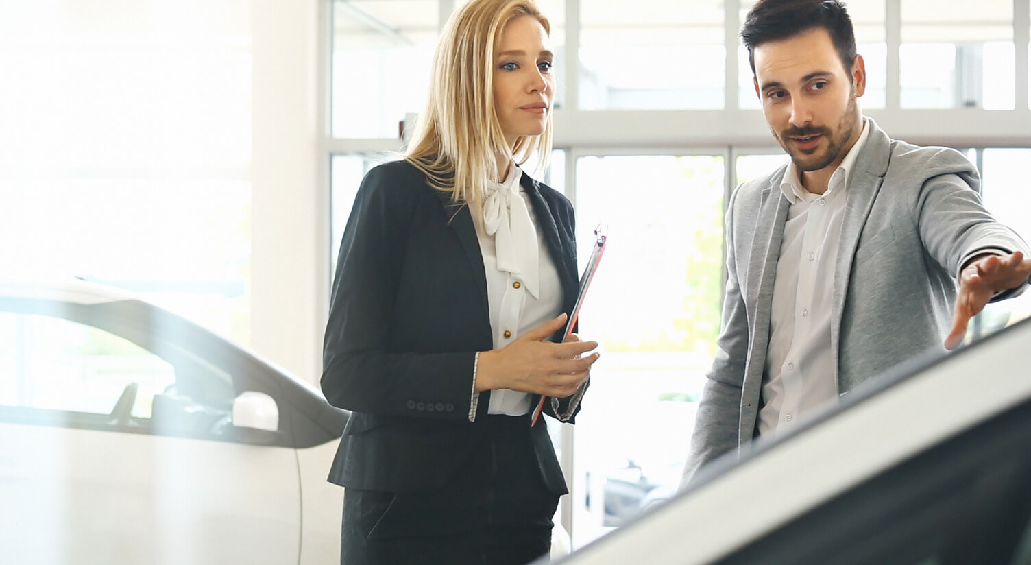 woman and man discussing at a car showroom