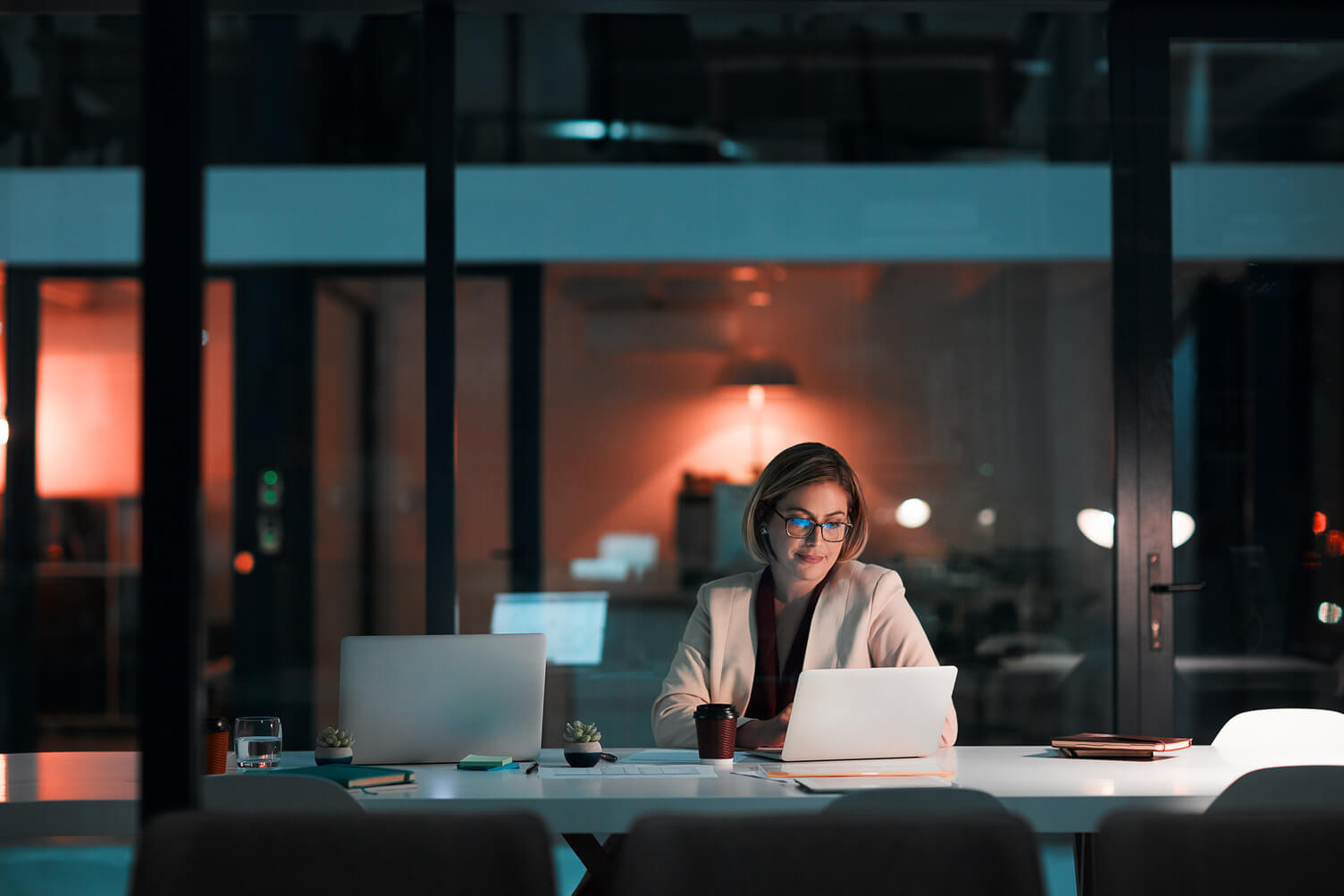 Businesswoman using a laptop at her desk during a late night at work