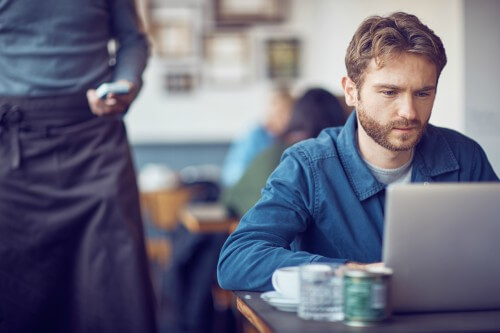 Man on laptop in a cafe