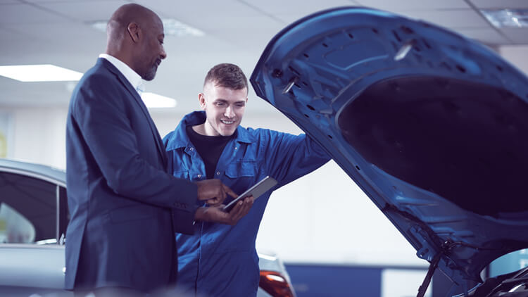 Car showroom manager checking a car with a mechanic