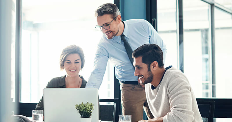 Colleagues gathered around a laptop