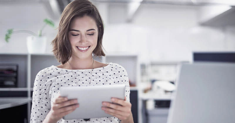 Woman holding a tablet while smiling